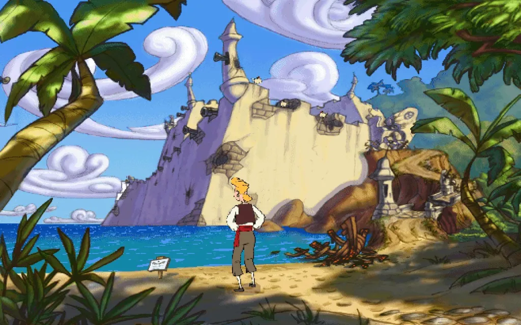 Guybrush Threepwood standing on the beach of Puerto Pollo, a plaque to his left explaining that Elaine has been kidnapped.